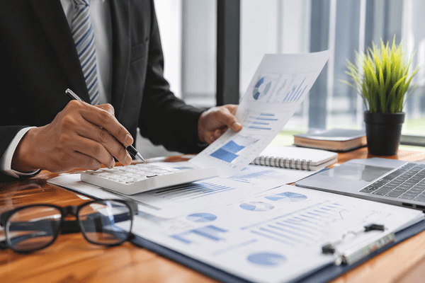 Gestor analisando relatórios financeiros, gráficos e indicadores em escritório corporativo, representando avaliação da qualidade da gestão de um RPPS.